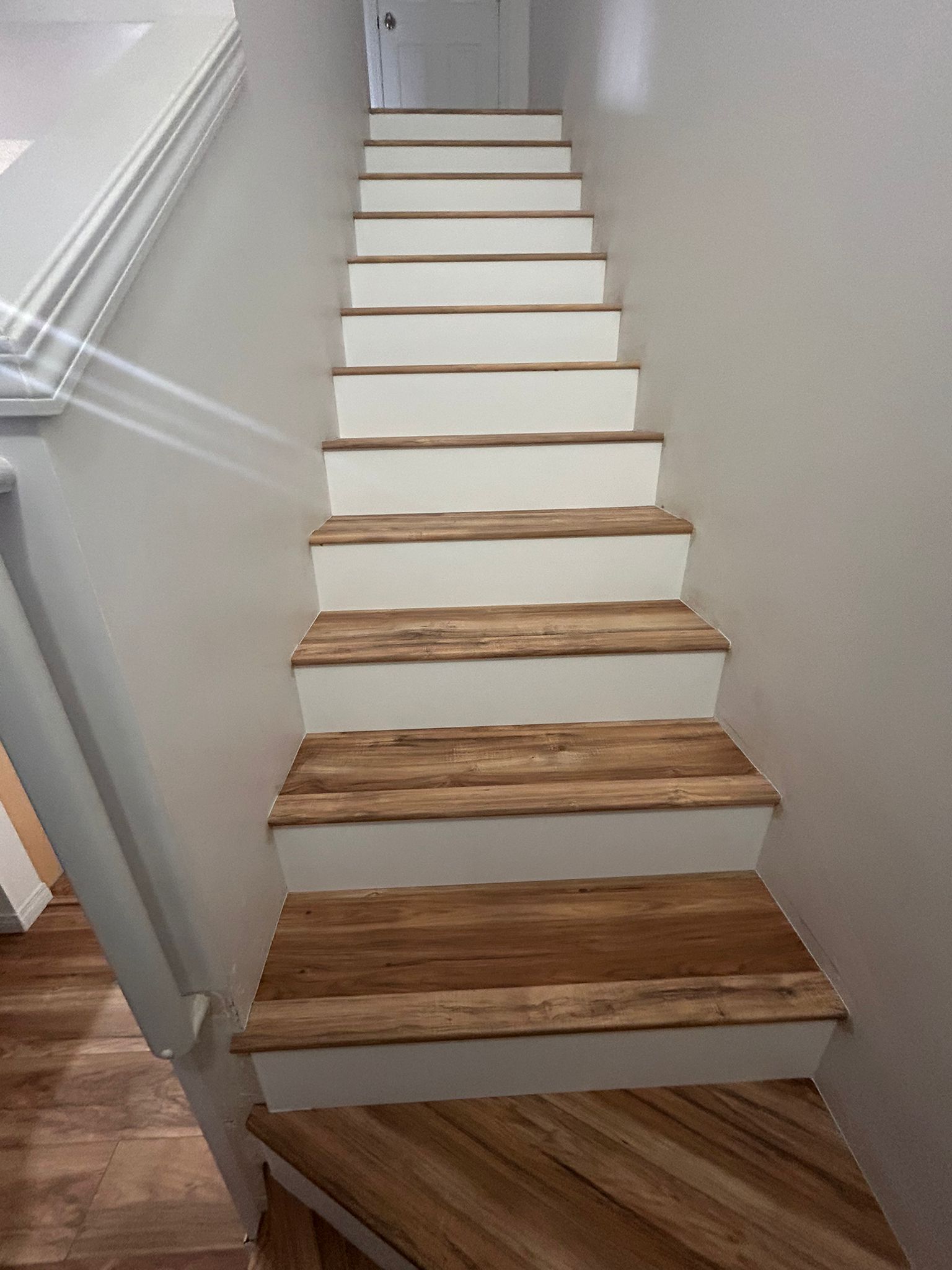 This stunning Southwest home features decorative laminate flooring on the treads, complemented by a clean white aesthetic on the risers.